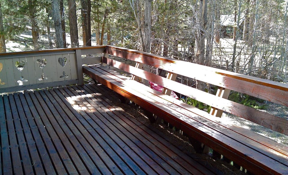 Redwood deck with built-in bench runs the full width of the home.