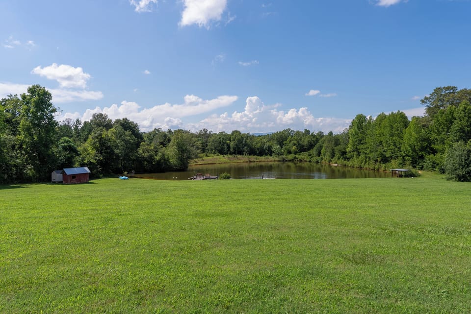 Wide-open lawn, pond views, and a broad mountain horizon.