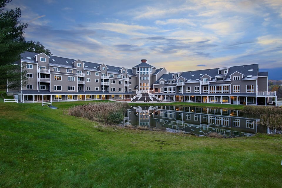 Resort exterior with mountain views and pond.