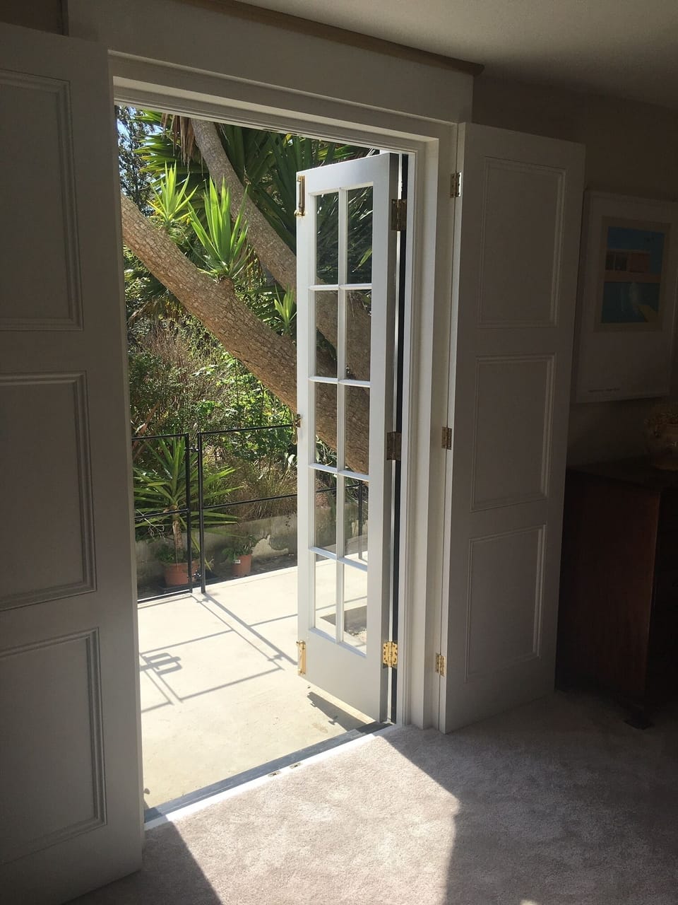 Bedroom flows into tropical garden with private veranda; table and recliners