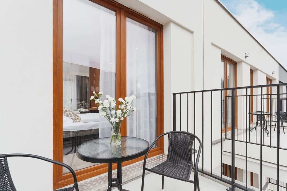 Spacious balcony with outdoor furniture. 