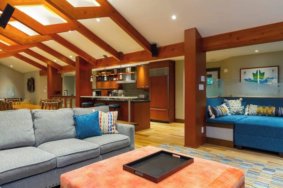 - Bright lounge area with colorful seating and open flow to kitchen  
- Wood-accented beams and cozy textures enhance the inviting feel  
- Perfect for relaxing, reading, or chatting with friends  
