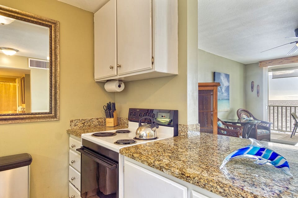 Cook meals with ease in the kitchen, featuring appliances, cookware, and a pass-thru to the ocean-view.
