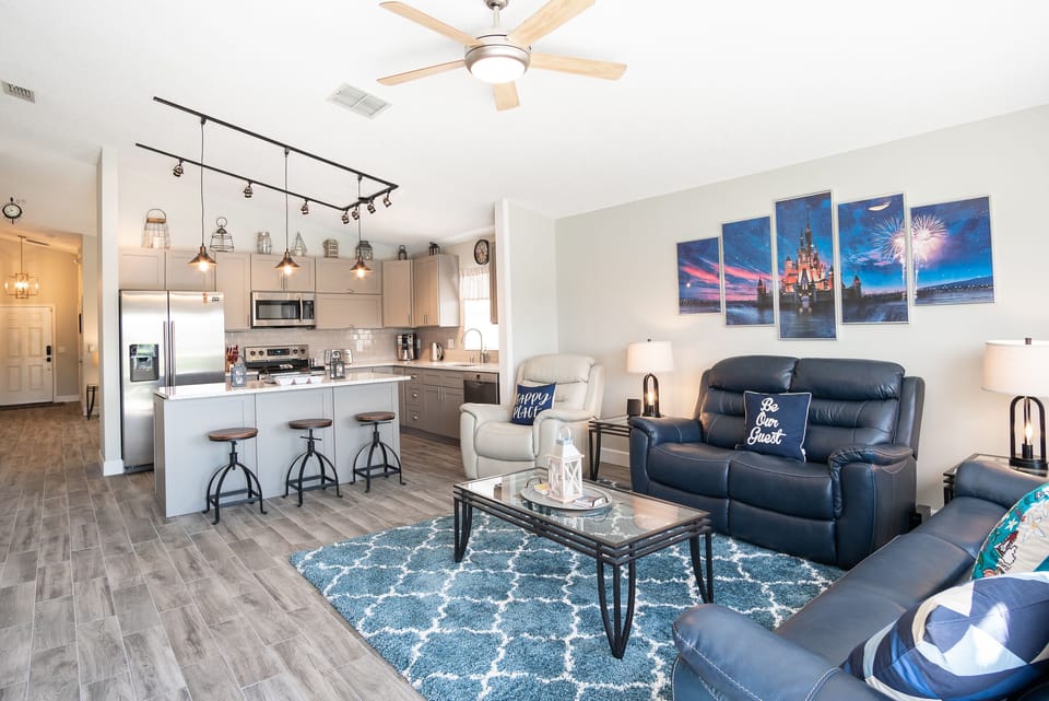 Open concept living room and kitchen with seating, breakfast bar, and modern lighting.