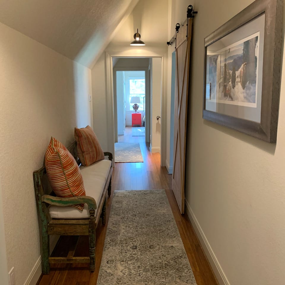 Upstairs hall from east bedroom to west bedroom past family room with barn door.