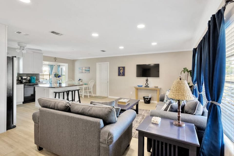 The living room has a queen sleeper sofa bed, room darkening shades, and a large Smart TV.