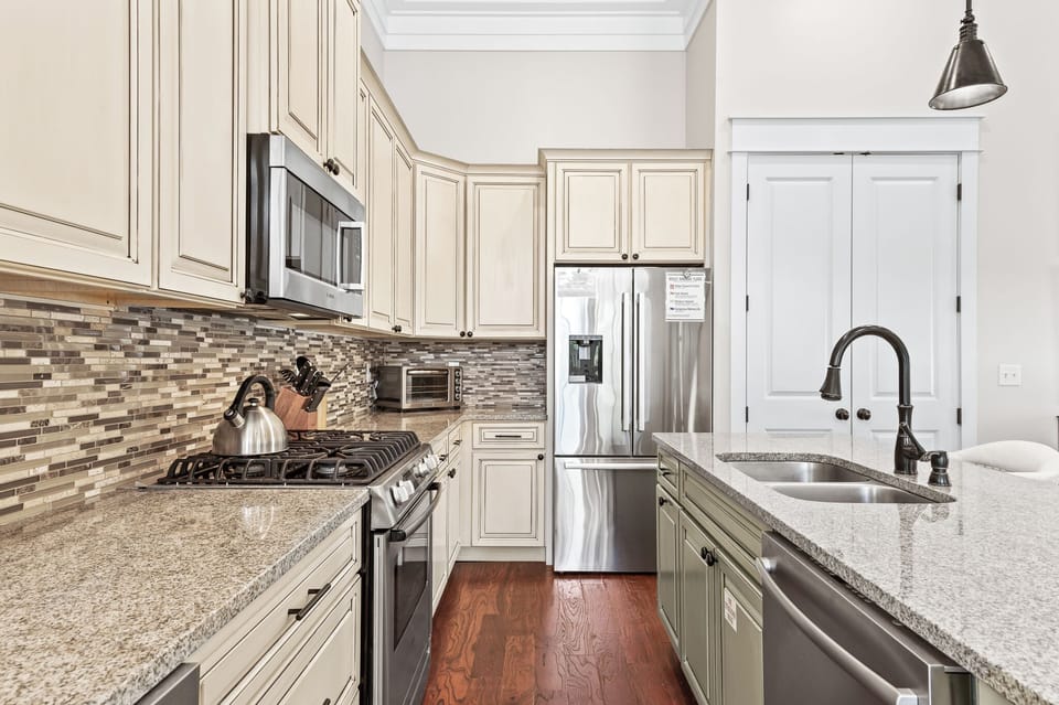Kitchen with granite countertops, tile backsplash, and stainless steel appliances