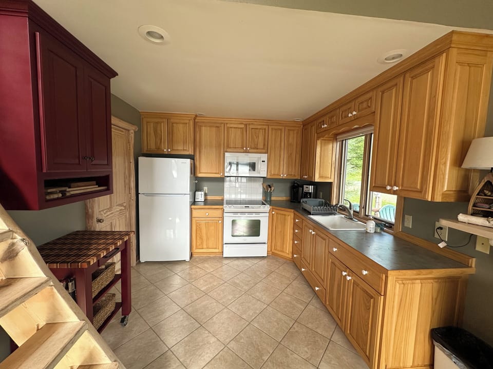 Kitchen is stocked with dishes, utensils, cookware,  and bakeware.