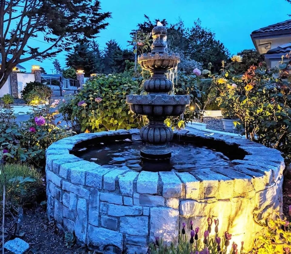The courtyard fountain in the evening with lights & roses. :)