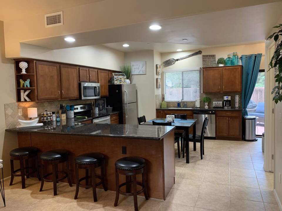 Four bar stools nestled beneath granite counter top.
