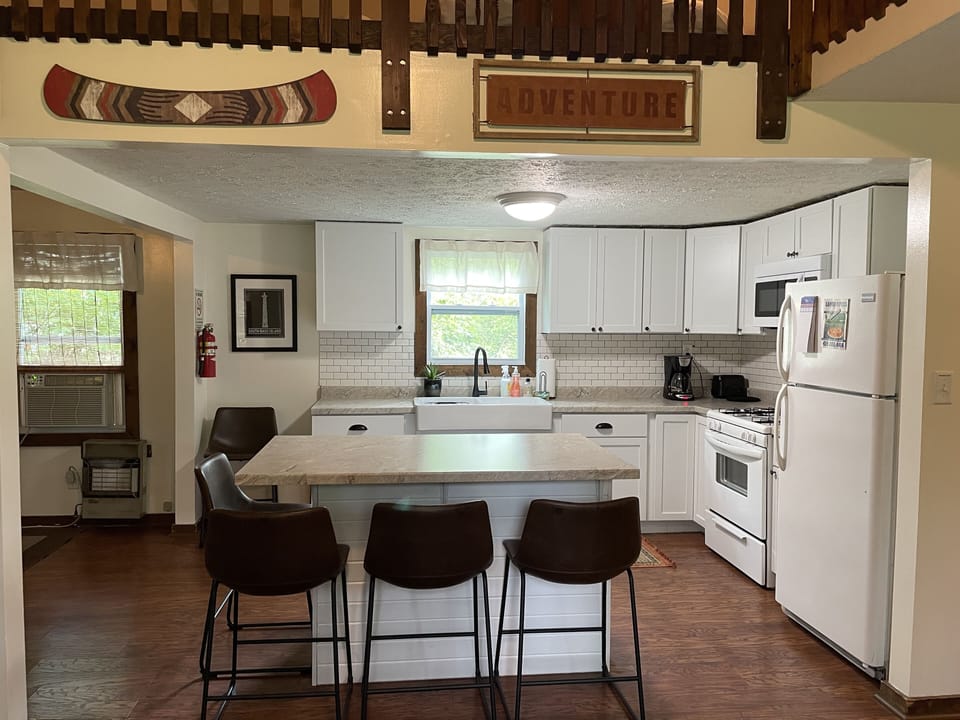 Kitchen fully stocked with silverware, cookware, dishes, and cups.