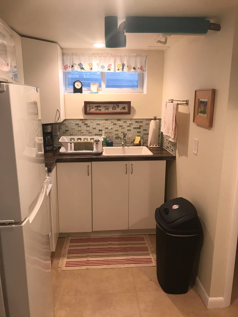 Kitchenette. The electric stove is behind the fridge and includes an oven. 