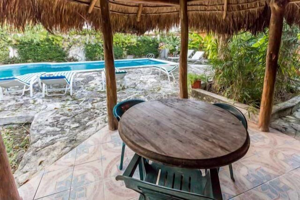 A shaded outdoor eating area sits next to the pool