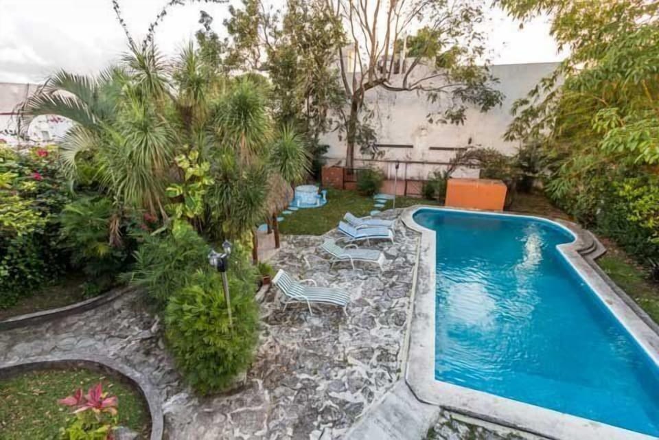 The large backyard has a pool, lots of seating, and a small shaded outdoor eating area