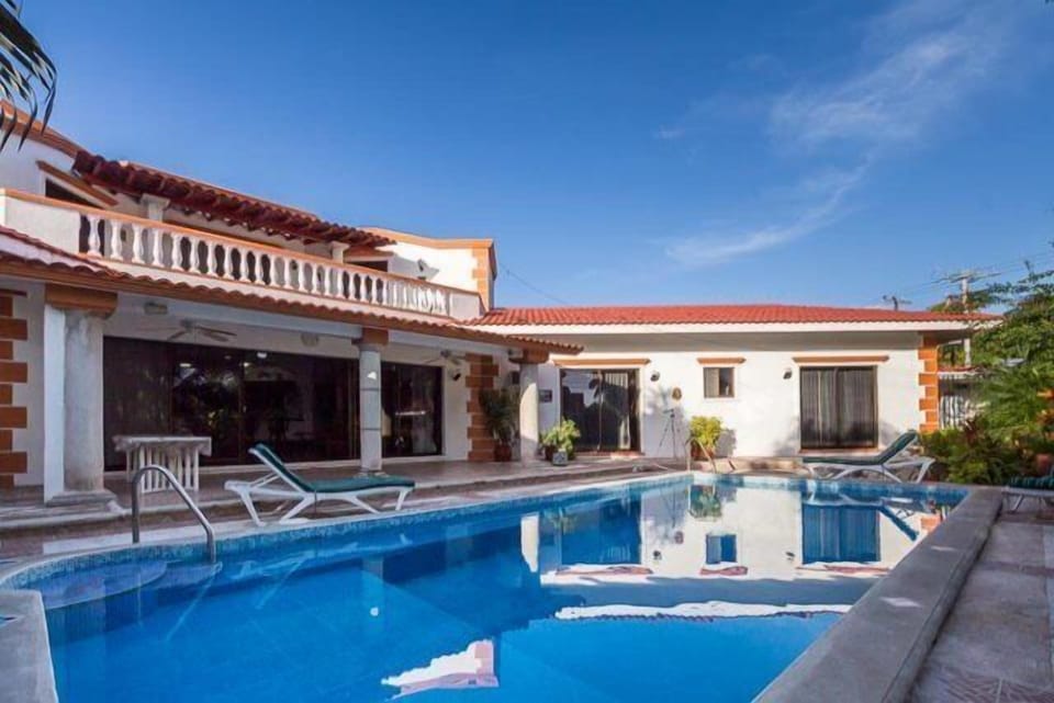 A view of the pool and home upon entering the property