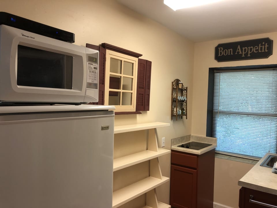 Kitchenette with refrigerator, microwave, built in two burner glass top range