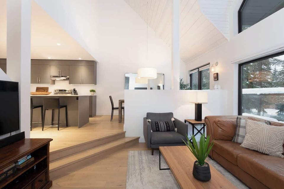 - Open-concept living with natural light and seamless modern design  
- Steps connect living room and kitchen for easy entertaining flow  
- Cozy interiors with scenic forest views create a warm mountain vibe  