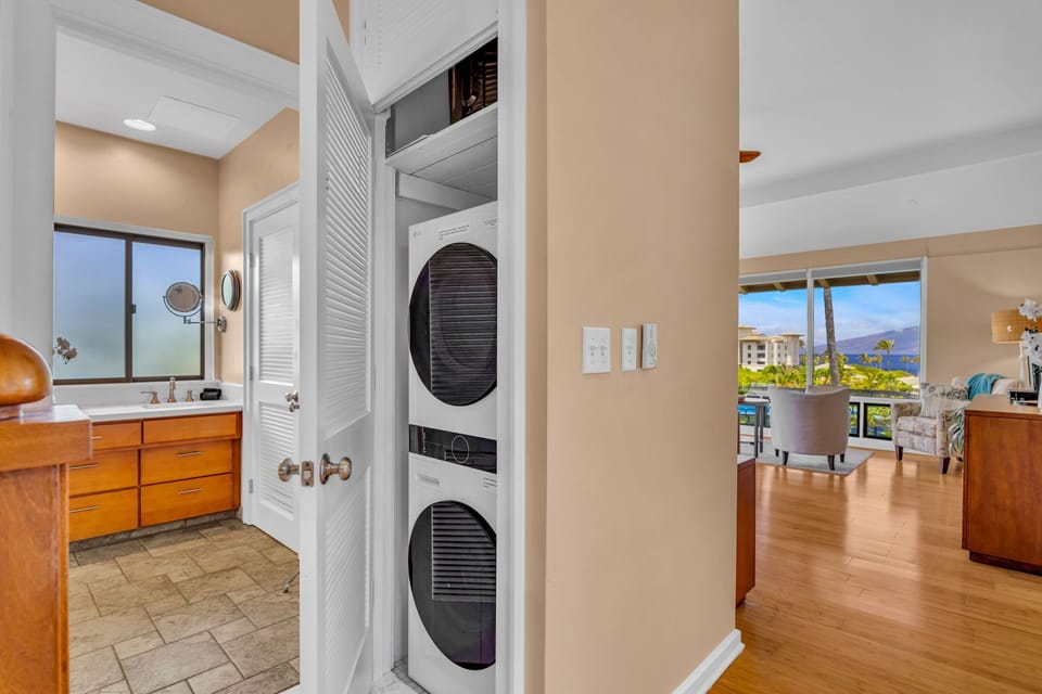 Compact laundry nook with stacked washer/dryer conveniently located off of the main bathroom