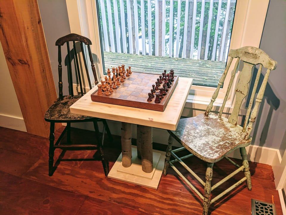 Chess nook with handcrafted Birch leg table and picture window view of the lake