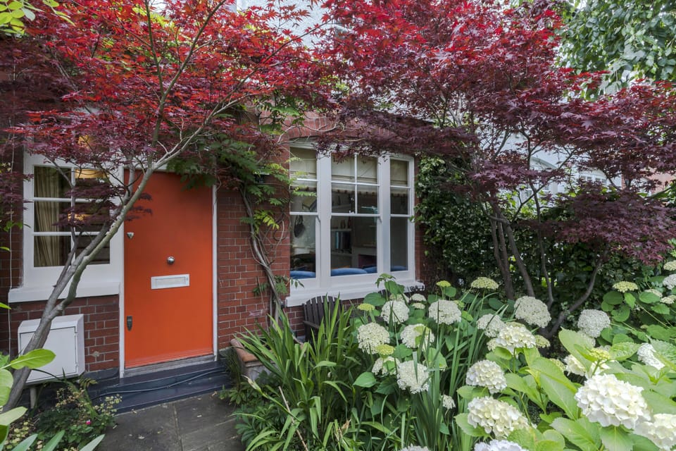 Lush private front garden with a white picket fence