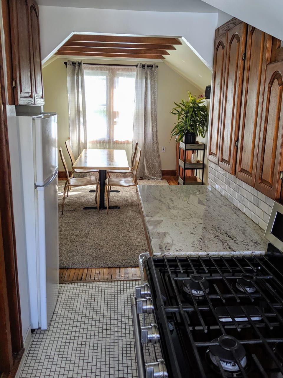 Galley style kitchen, with large stainless steel gas stove. 