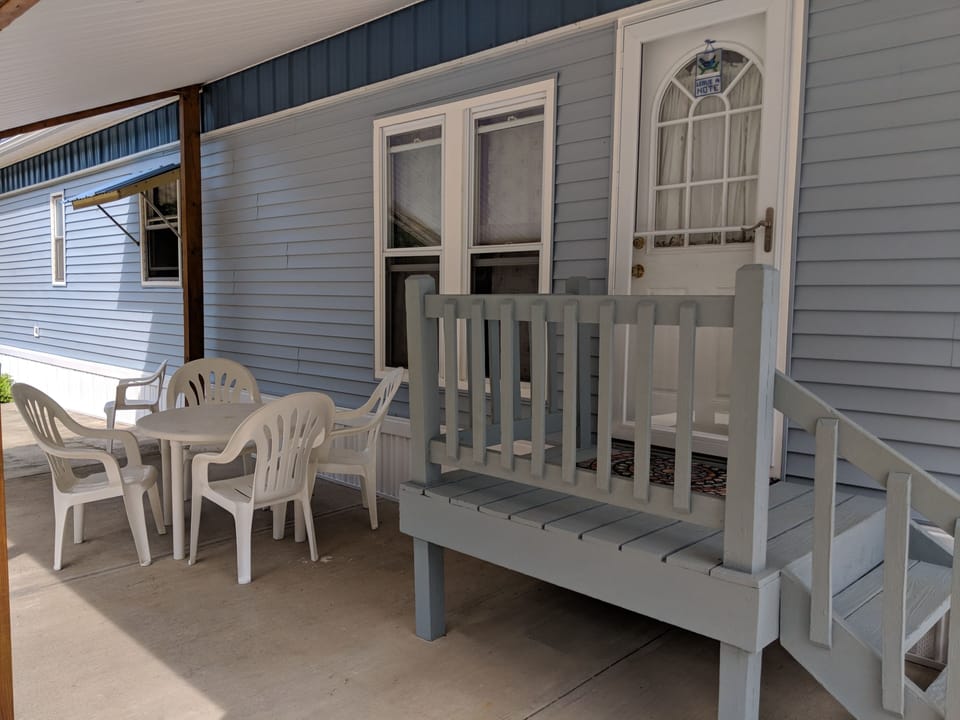 Covered front entrance with concrete driveway and patio seating