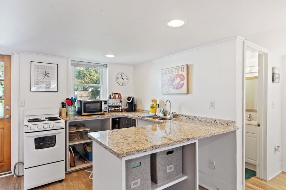 Kitchenette equipped with stove and cooking tools to eat in. 