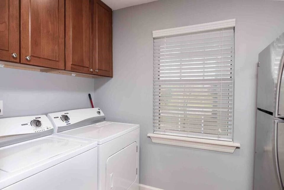 Laundry area with a full size washer and dryer. Laundry detergent and dryer sheets are provided. 