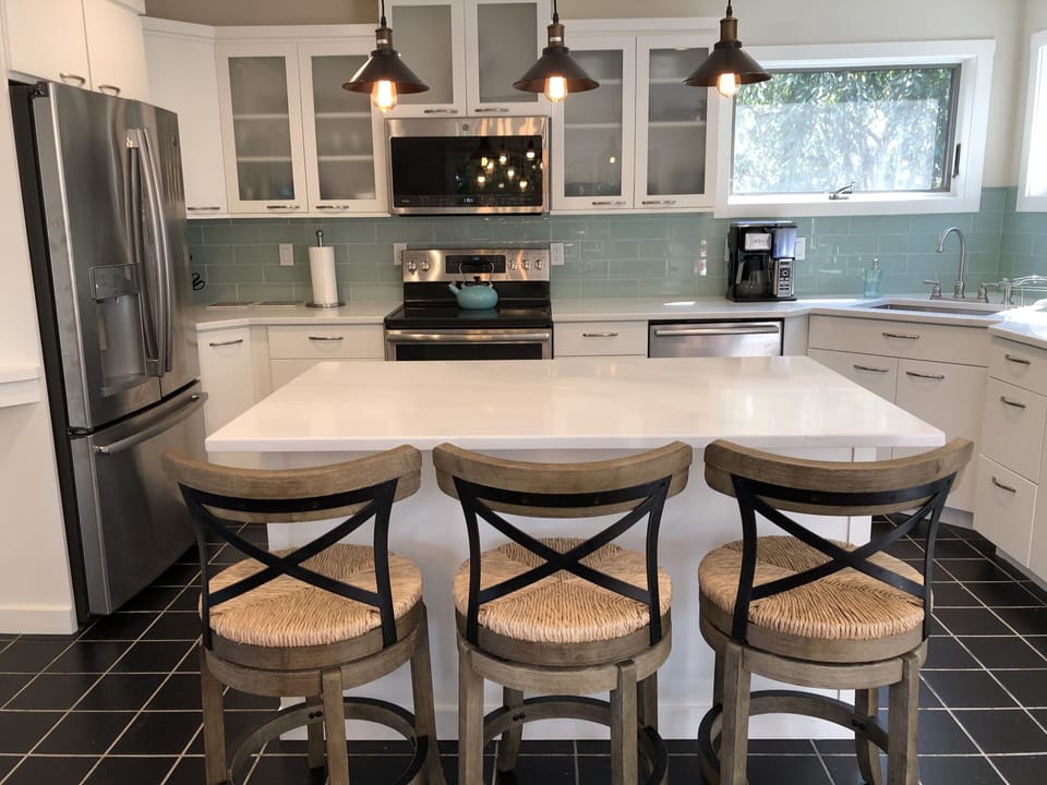 Newly renovated windowed kitchen with center island and barstools