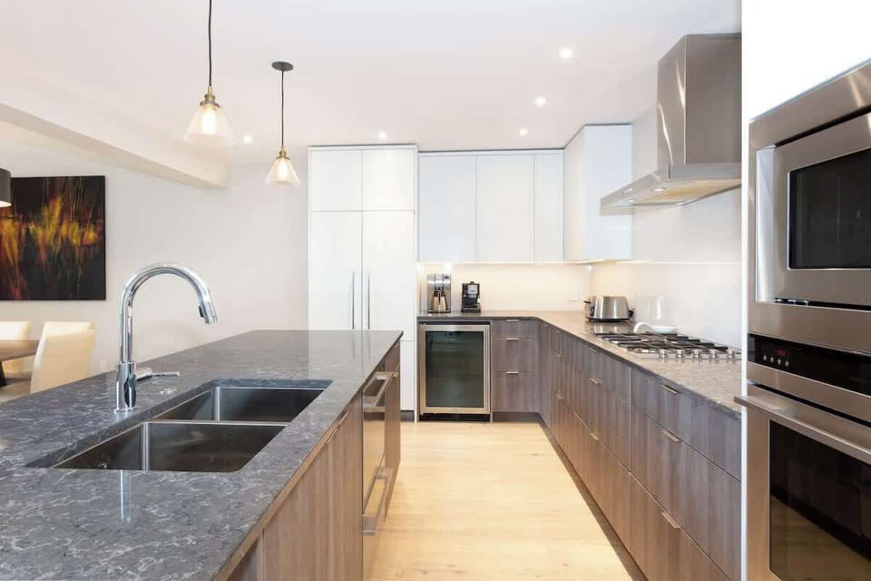 - Gourmet kitchen with granite island and premium appliances  
- Sleek cabinetry, wine fridge, and pendant lighting accents  
- Ideal for home-cooked meals after skiing or hiking adventures  
