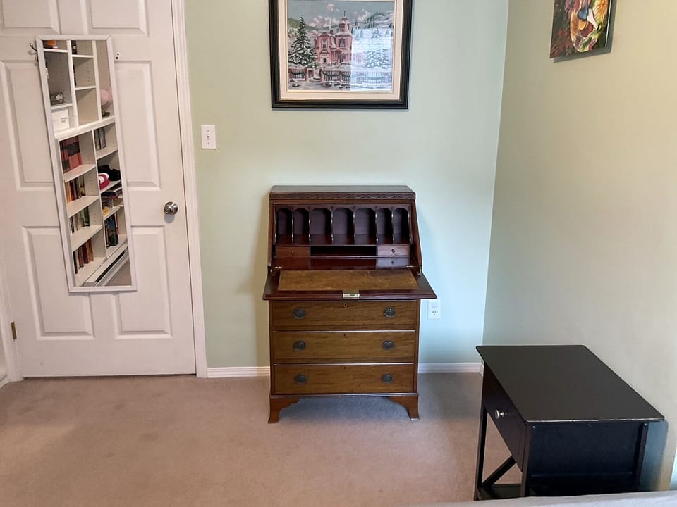 Antique drop-front desk adds character and a handy surface in Bedroom 2.