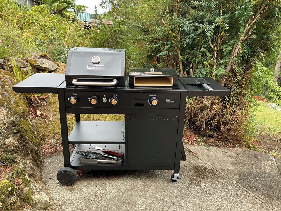 BakerStone setup with gas grill, griddle, pizza oven and tools provided.