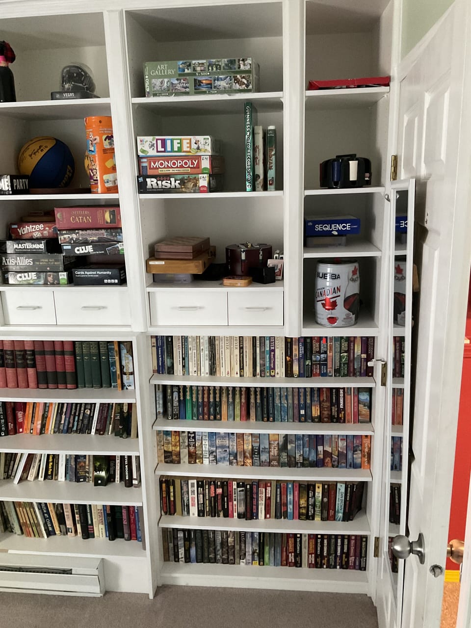 Wall-to-wall bookshelf with books, board games, puzzles, and more