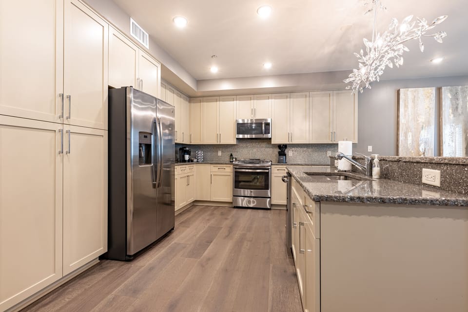 Cook and dine easily in the fully stocked kitchen, equipped with all stainless steel appliances, gas range, basic cookware, and a dining area for a comfortable meal at home. Entertain at the island with seating for three.