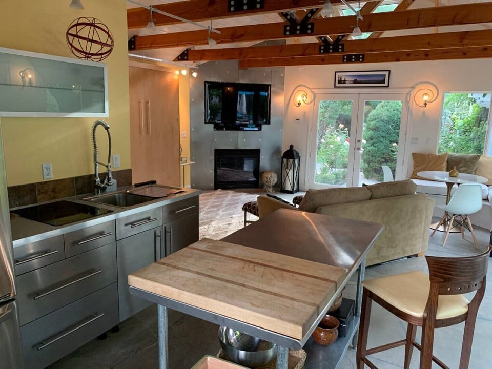 Overlooking living area with a stainless steel wall housing the fireplace & TV. 
