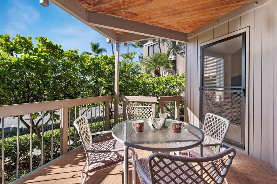 Your private balcony offers a peaceful spot to enjoy morning coffee surrounded by lush tropical greenery and swaying palms.