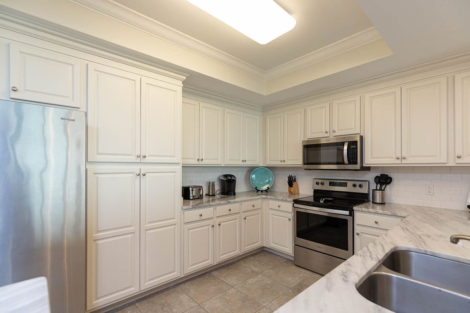 Prepare meals in this kitchen with elegant cabinetry, stainless appliances, and sleek countertops