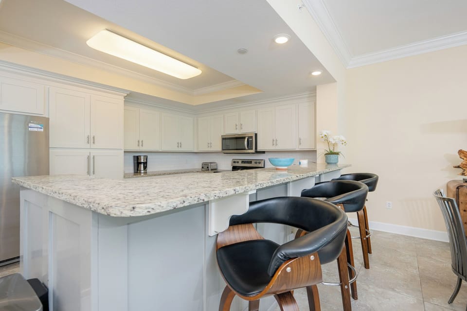 Unwind at the breakfast bar, savoring your morning coffee while taking in the welcoming kitchen atmosphere