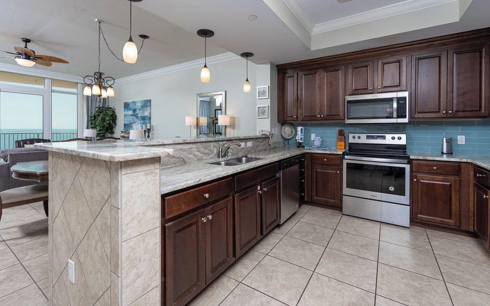 Create culinary delights in this kitchen with stainless appliances and stylish backsplash, enjoying the balcony breeze
