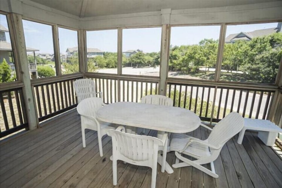 Step onto your screened porch with panoramic views of lush greenery and neighboring rooftops—a perfect spot for morning coffee or sunset dining in complete comfort.
