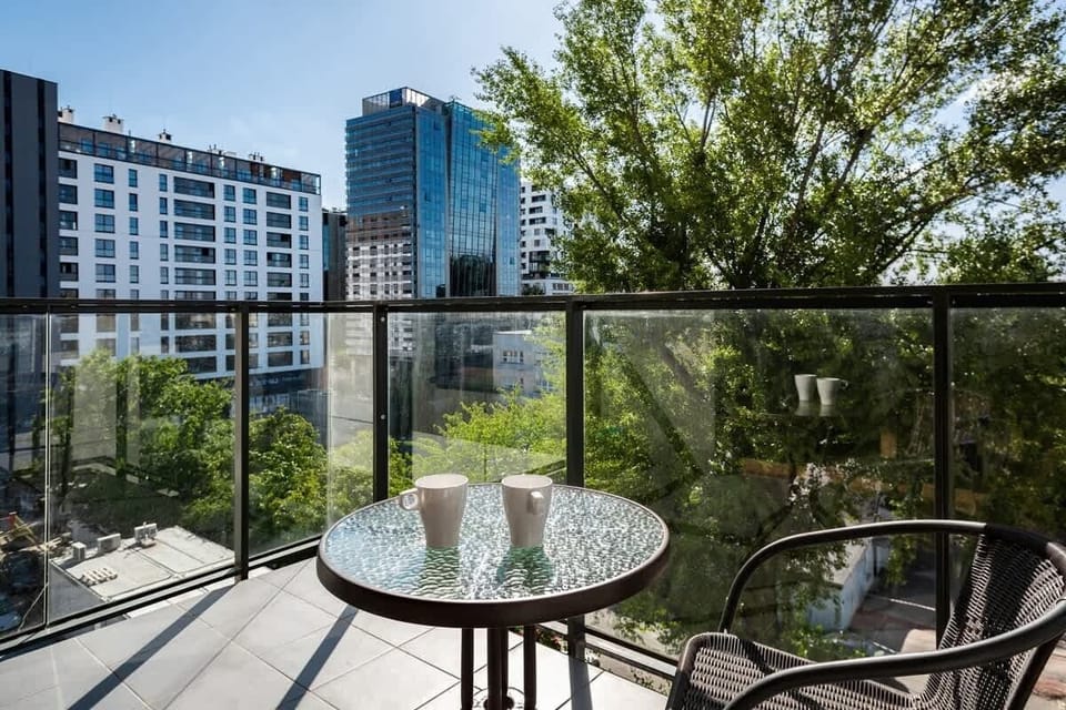 Spacious terrace with a table and chairs, perfect for morning coffee with a city view.