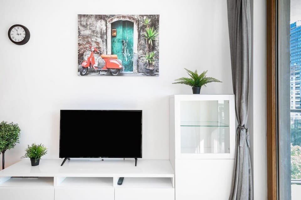 White and modern interior with a flat-screen TV and access to the balcony.