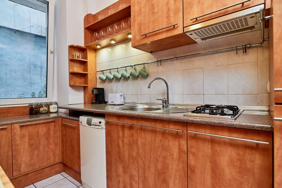 Wooden and atmospheric independent kitchen with a toaster, a coffee machine, and a microwave.