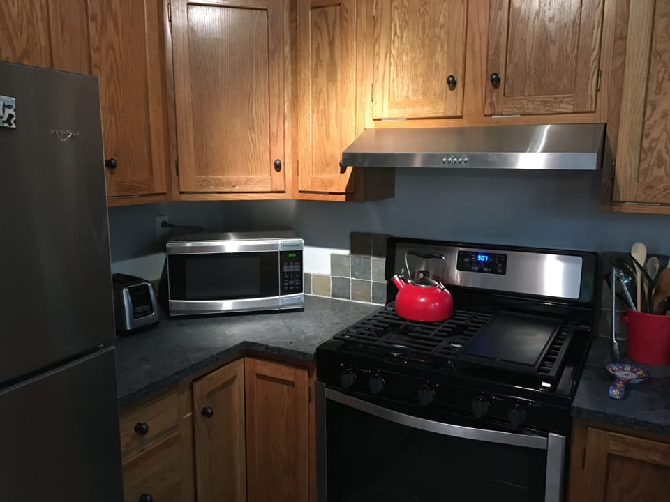 View of 5 burner gas stove with double oven below and microwave.