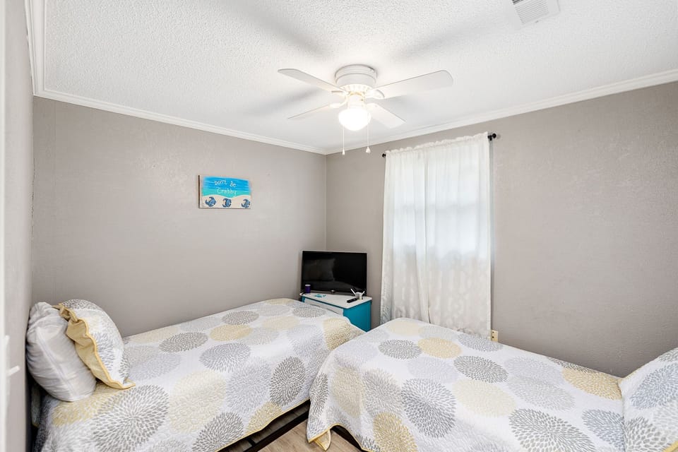 Guest room has two twin beds with a smart tv.