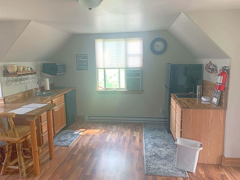 Kitchen area with coffee pot, fridge, hot plate, and microwave