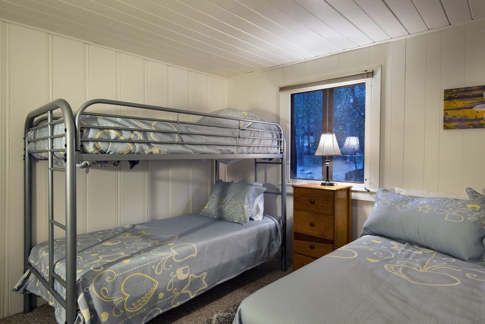 The third bedroom has a full bed and a set of bunk beds, with access to the bathroom in the hall.
