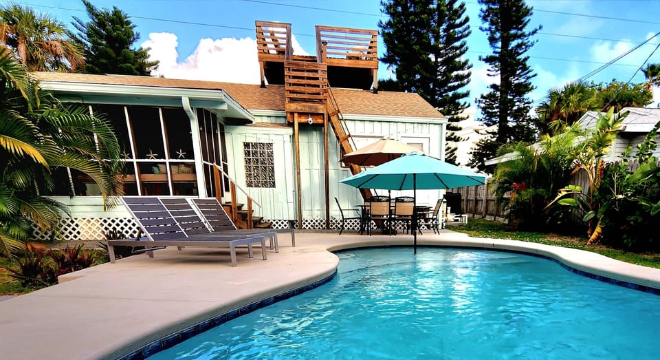 Heated pool surrounded by oasis and unique rooftop deck above.