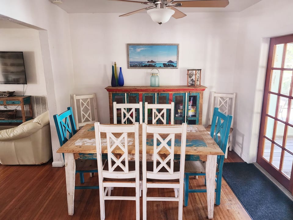 Dining room with 8 chairs, looks out to porch.