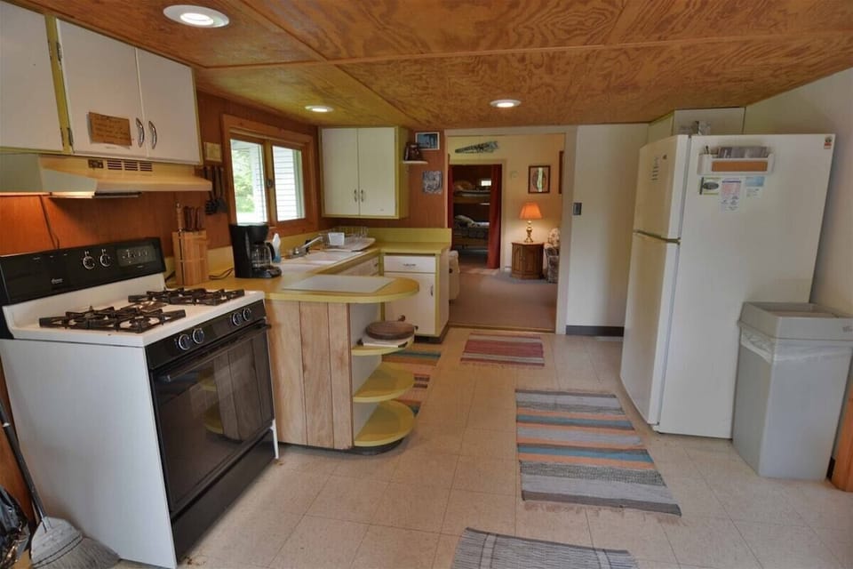 Kitchen has full sized appliances and pots, pans, dishes and utensils.